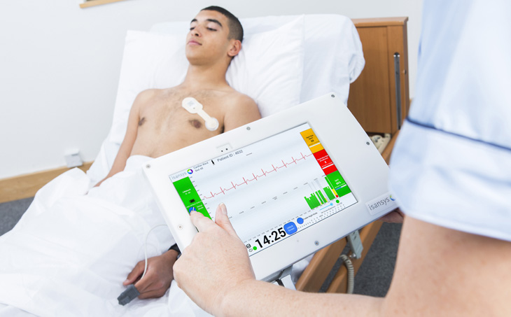 patient-in-bed-with-nurse-holding-monitoring-device