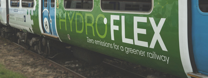 Side of train with large logo on the side reading "HydroFLEX - Zero emissions for a greener railway"