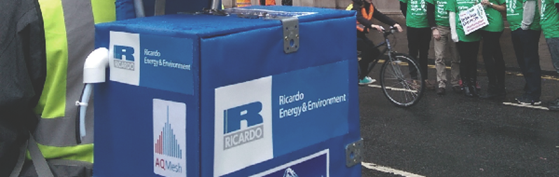 Ricardo Energy and Environment logos on a portable air quality monitor sat in a street environment.