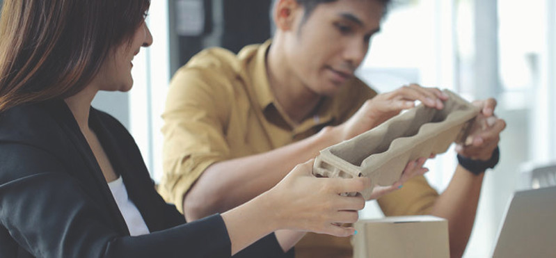 Two people looking at cardboard packaging