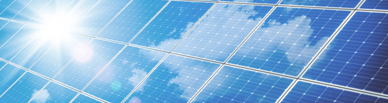 Array of solar cells with sun and clouds reflected on their surface