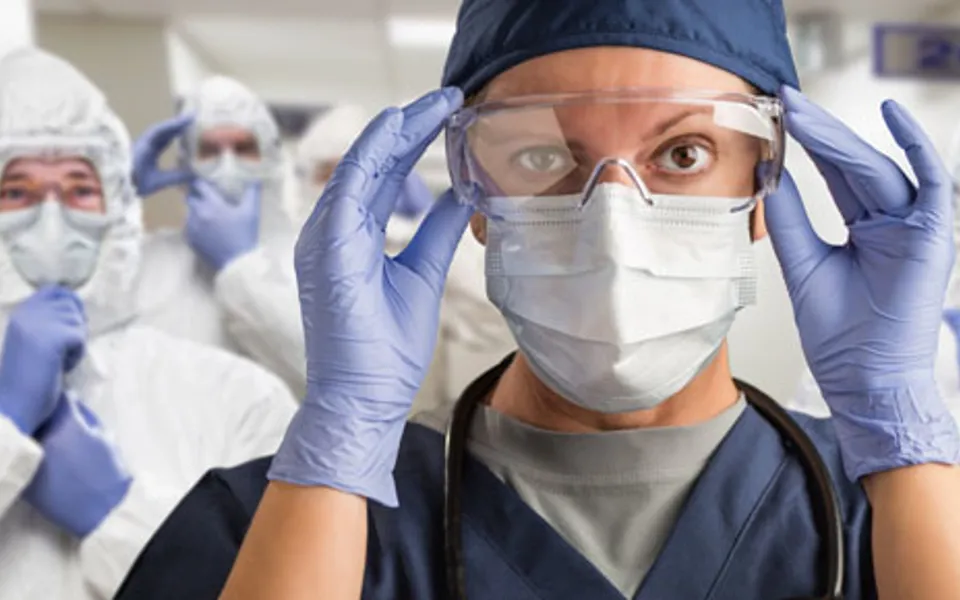 Doctor Wearing Mask And Eye Goggle With People Wearing Ppe Full Suit
